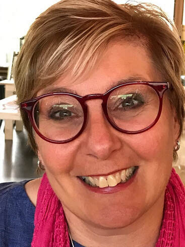 Dr. Sandra Staffieri wearing glasses smiling broadly at camera